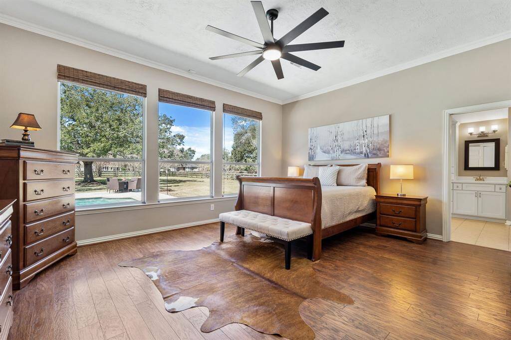 Relax and unwind after a long day in the comfort of this spacious Primary Retreat. Three large windows, adorned with bamboo-woven blinds, provide a panoramic view of the pastoral Backyard views.