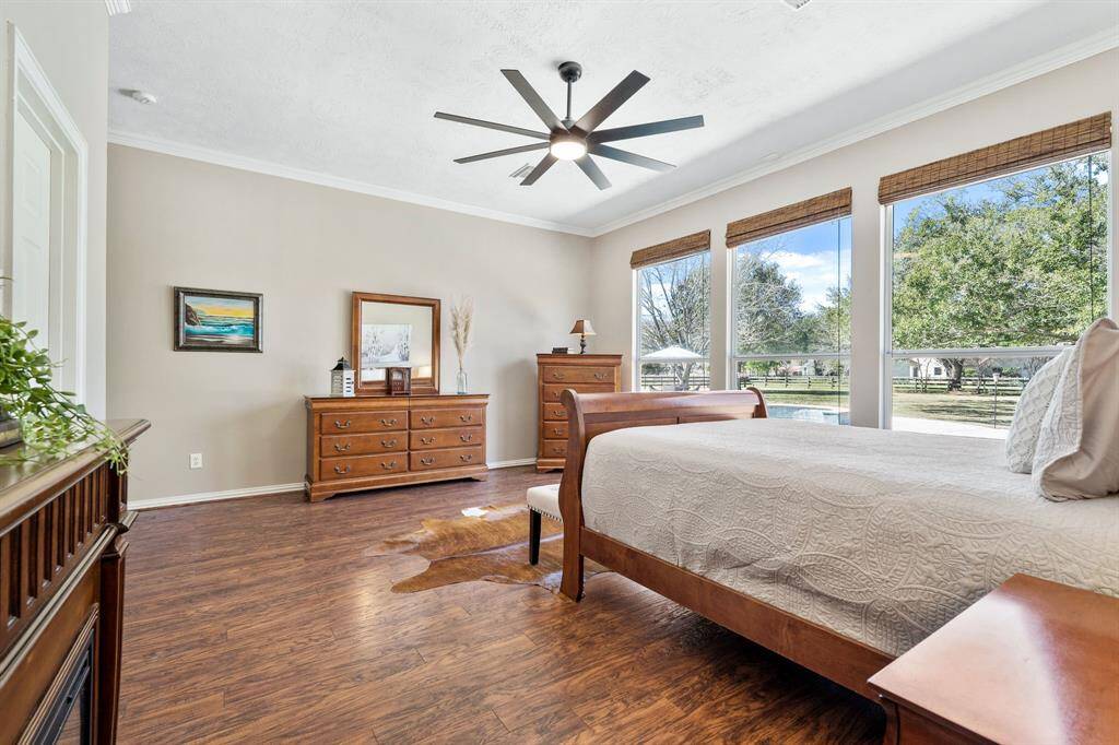 The Primary Bedroom is located off the Living Room, on a quiet and private wing of the home. The space includes the laminate flooring, crown molding, a high-end ceiling fan, and plenty of space to accommodate additional furniture like a dresser, armoire, and/or small desk.