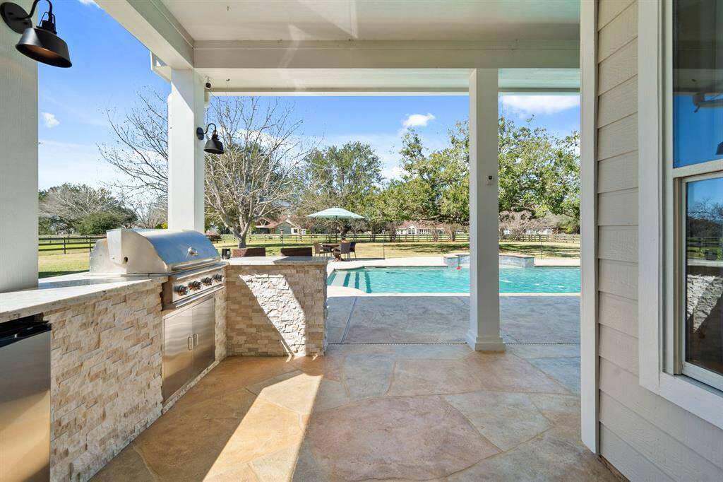 A door off the Kitchen conveniently provides direct access to this impressive summer Kitchen! Located under the protection of the covered Back Porch, with a picturesque view, the master griller will feel right at home!