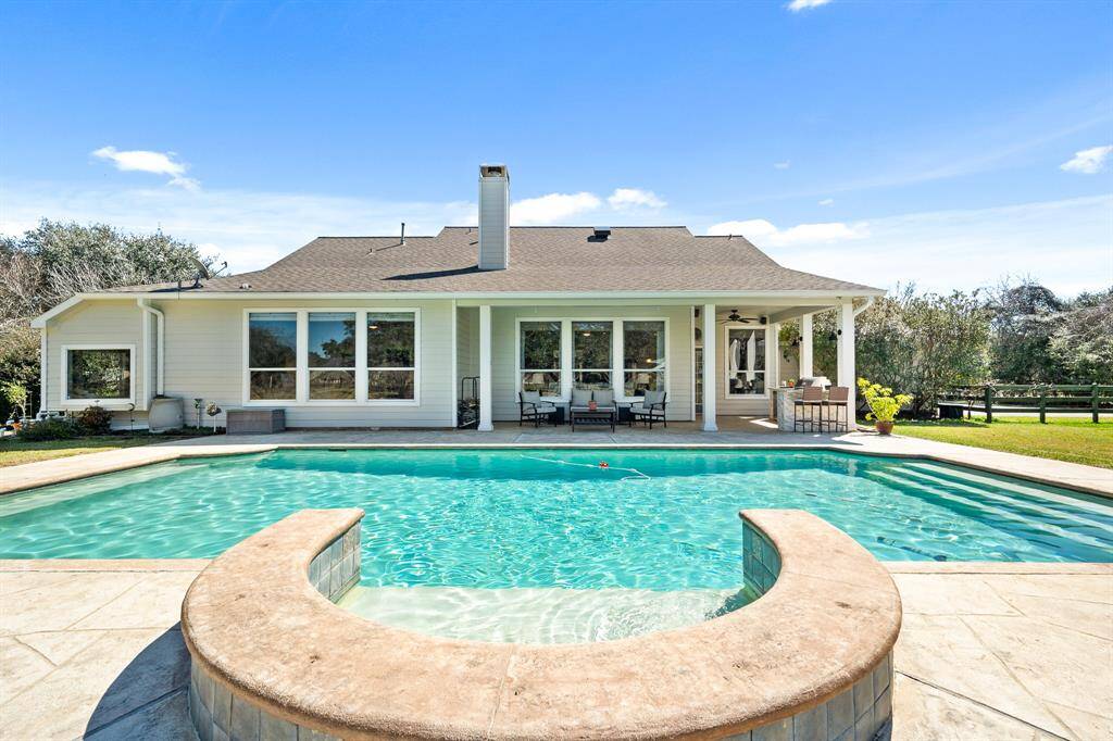 This expansive pool boasts a tanning shelf, a gradual entry, and non-slip, stamped concrete surround.