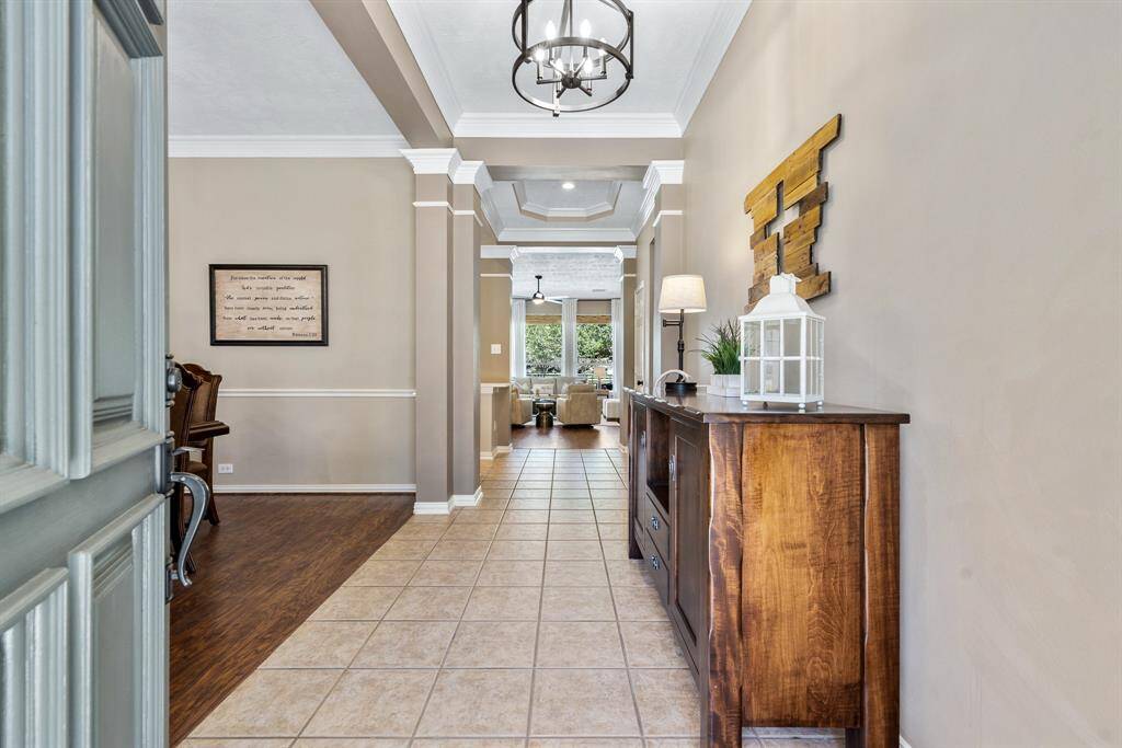 Upon entering the home, guests are greeted by 10’ ceilings, a warm color pallet, and sunlight pouring in through the windows ahead. The Dining Room is off to the left, while the Living Room is seen beyond the Foyer.