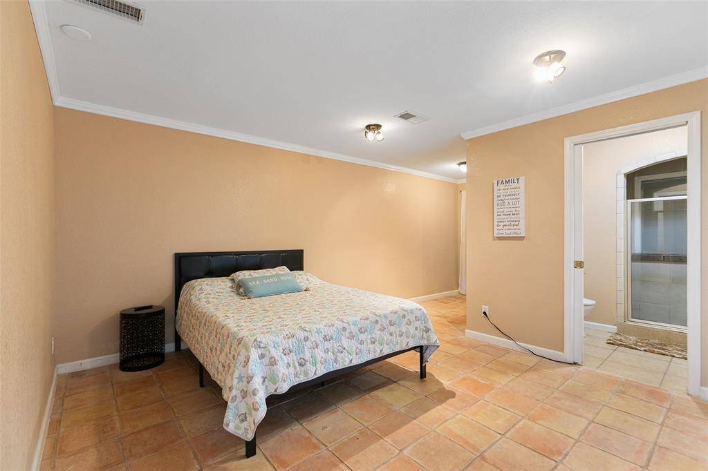 Large primary bedroom with ensuite bath, walk in closet, sliding doors to pool area and direct access to backyard.
