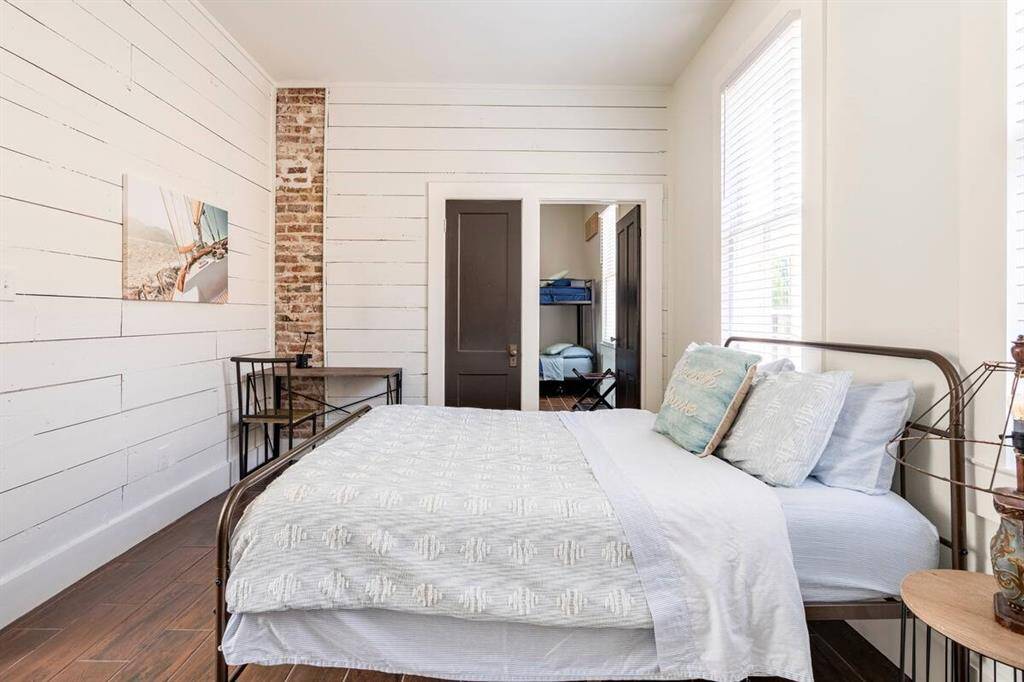 Bedroom 1 has space for a desk and includes charming exposed brick.