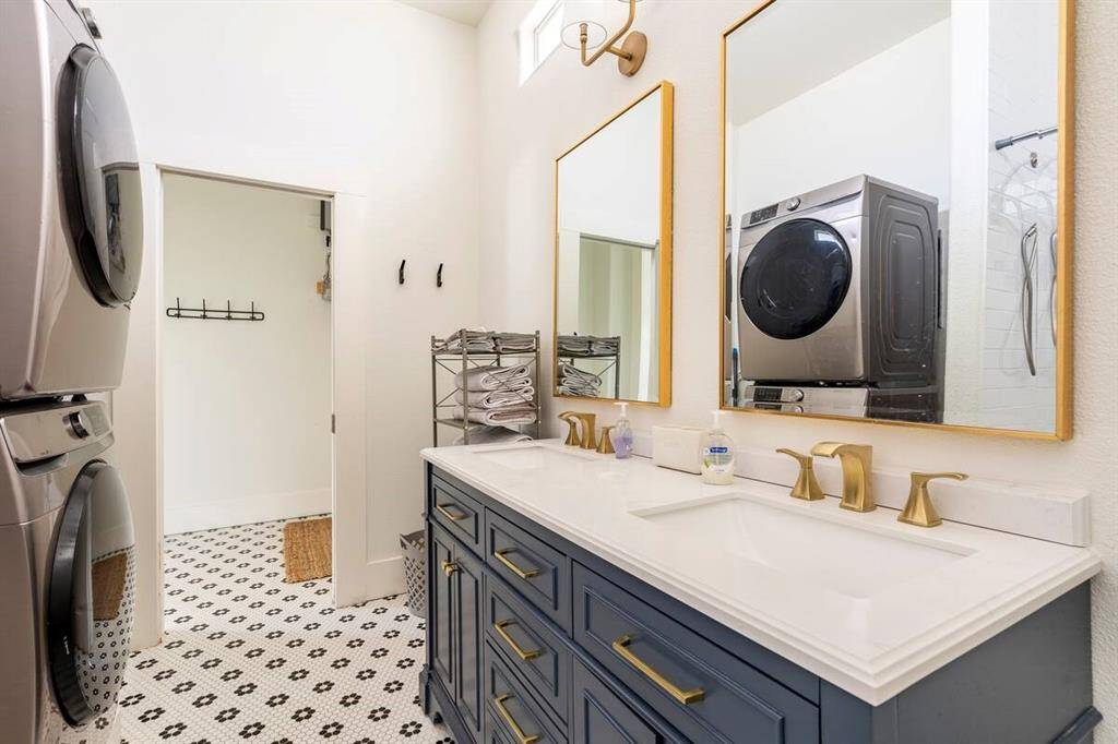 The stunning bathroom has a high ceilings and a dual vanity.