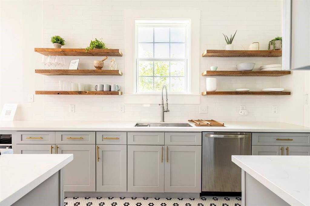 The kitchen has cabinet and floating shelf storage for an  elegant aesthetic.