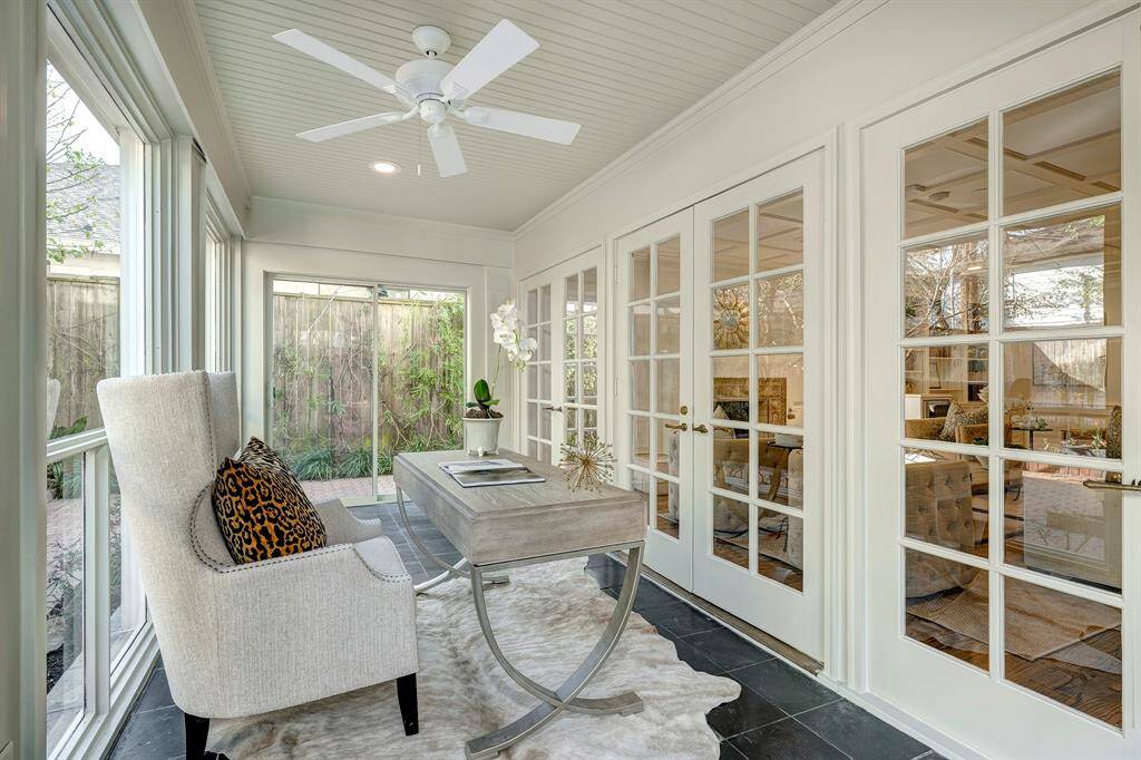 The private home office is accessed by the French doors from the den/library. This light and bright area includes a new* installed ceiling fan and freshly* painted walls in Nantucket Gray, a Sherwin Wiliams paint color. *February 2025 per Seller.