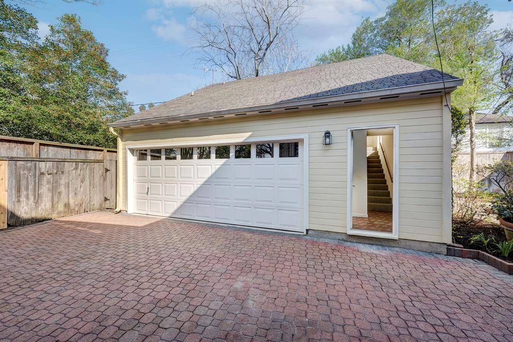 This photo of the detached two-car garage shows the staircase ascending to the guest quarters/aparement consisting of a good sized bedroom/flexible space, full-sized kitchen, bathroom and closet.