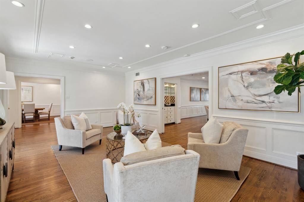 The lovely living room [21' x 13'], adjacent to the foyer, is one of many generously sized rooms perfect for entertaining at this traditional River Oaks residence. An abundance of natural light from southern exposure brightens this room. The first of three fireplaces is pictured to the left [east].