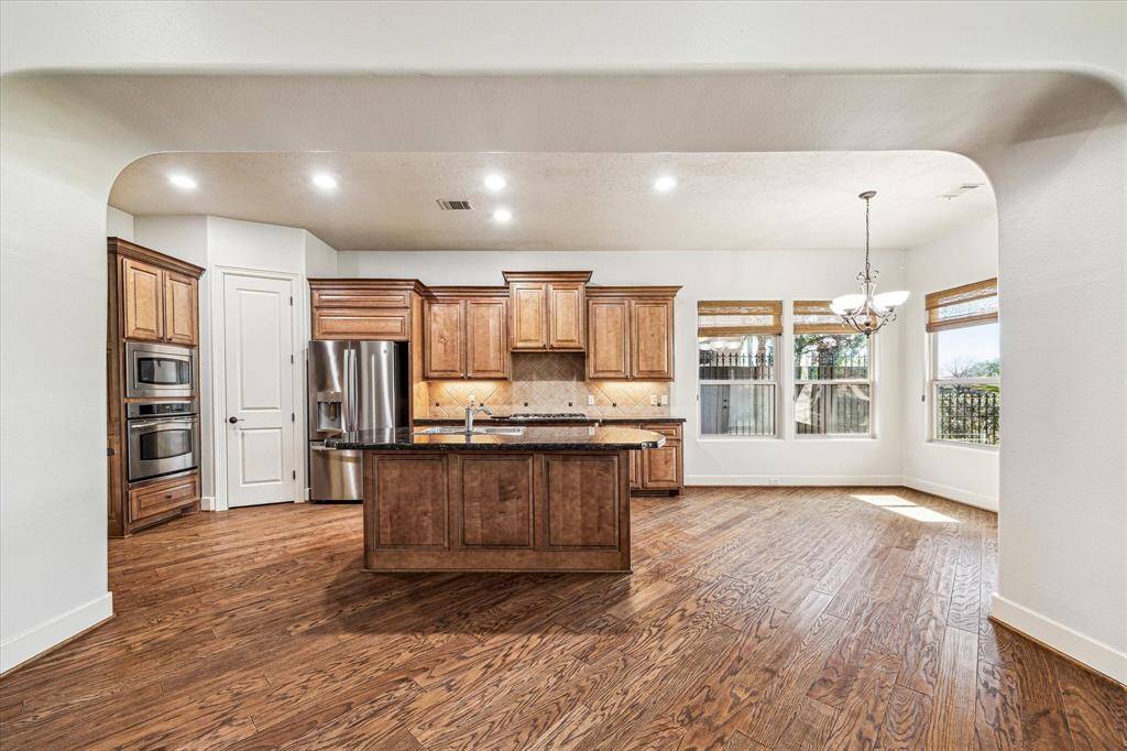 Stunning wood floors lead into the kitchen, featuring stainless steel appliances and newly installed gas cooktop. Large kitchen granite island overlooks the family room and views of the golf course are enjoyed from the breakfast room.
