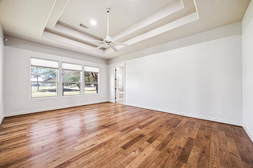 Hardwood floors enhance the room, and having them flow seamlessly from the living spaces into the primary bedroom adds a nice touch of elegance and continuity.