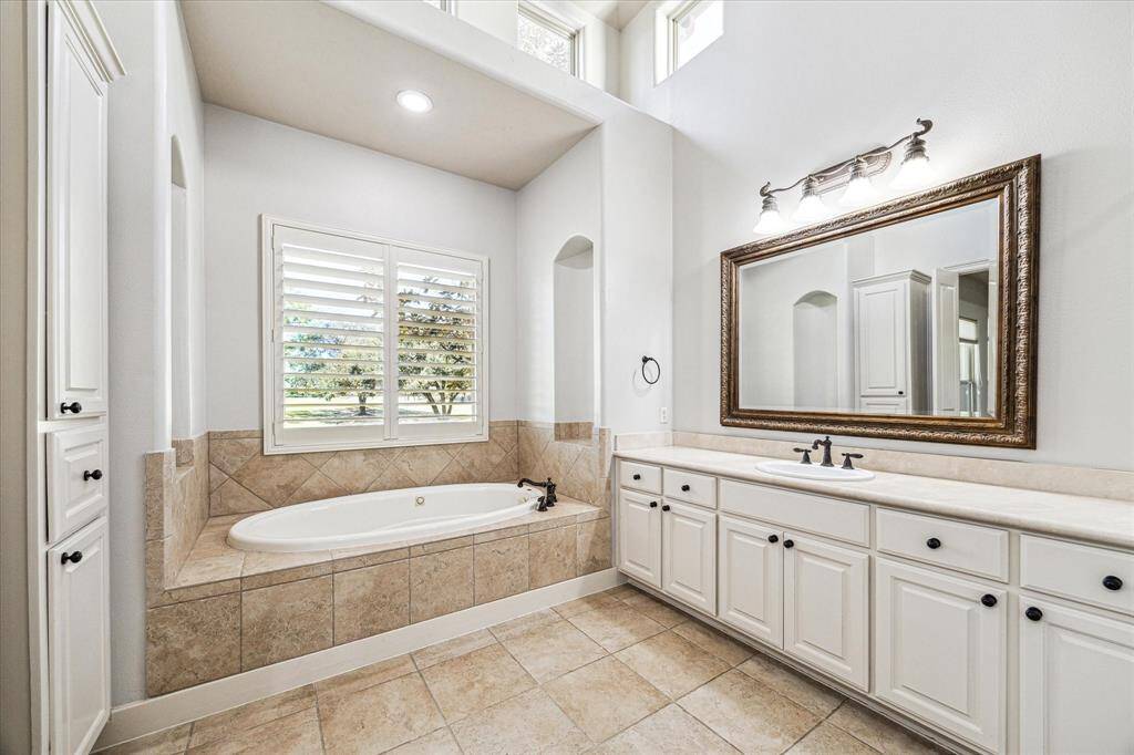 Indulge in the primary en-suite bathroom featuring a sunken tub, double sinks, a standalone shower, and an expansive closet.