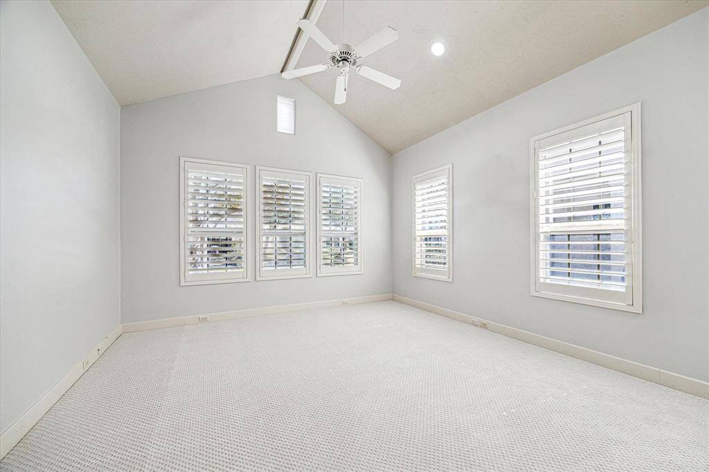 A spacious secondary bedroom has vaulted ceilings, plantation shutters, new carpet and ensuite bath offering the feel of another primary suite.