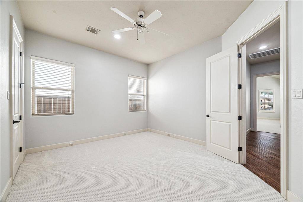 The third bedroom features new carpeting, Venetian blinds, a spacious closet, and easy access to the hallway bathroom.