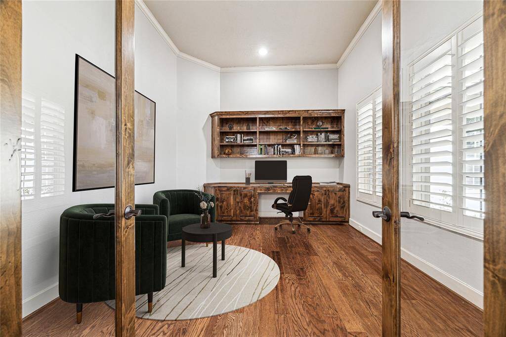 Step into the private study through elegant double glass doors featuring a built-in desk, shelving, recessed lights and plantation shutters. *Virtually Staged*