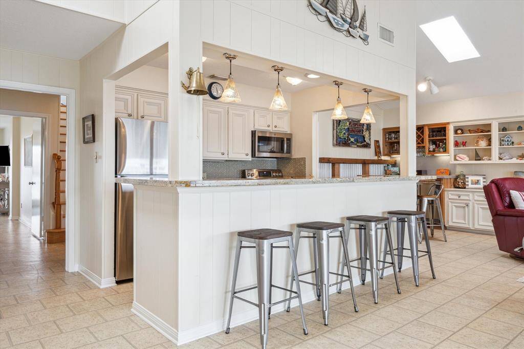 The galley style kitchen with breakfast bar seating makes it so easy for everyone to pitch in!  Recent upgrades with granite countertops and beautiful backsplash and lighting, create a warm and inviting space.