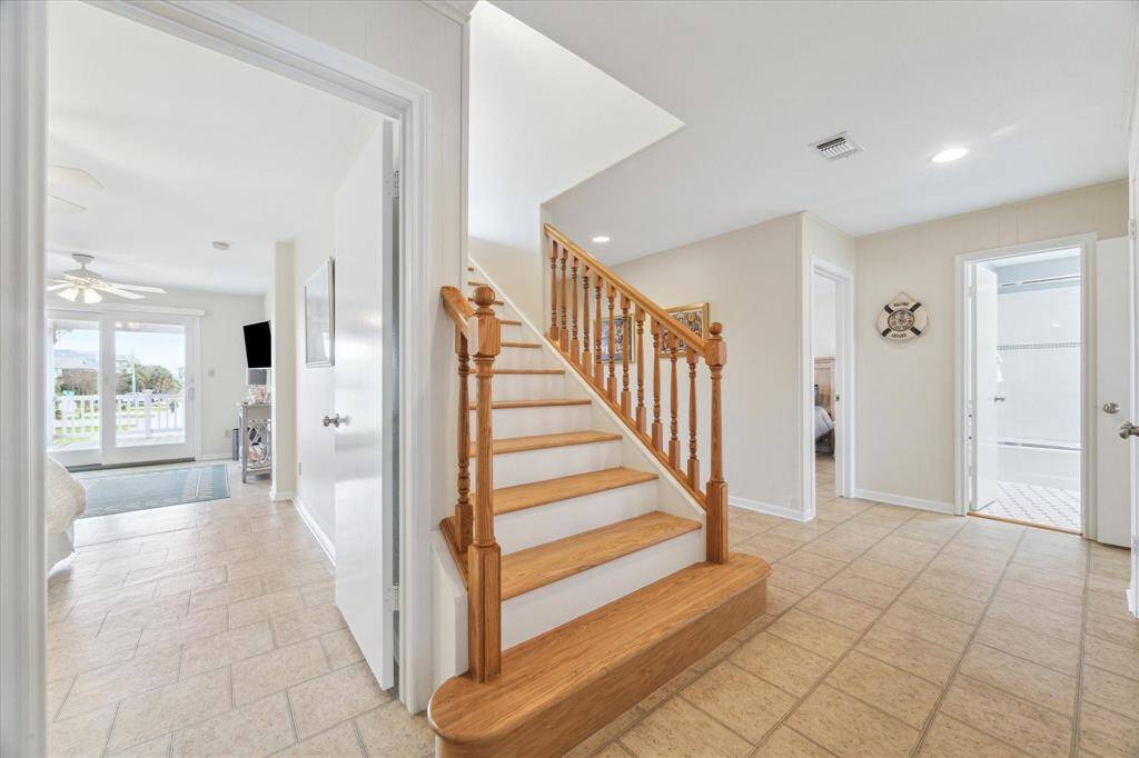 In 2018, this grand staircase was part of the remodel to add a wonderful primary retreat.  From this angle on the main floor, you can see two secondary bedrooms, a full bath and a third bedroom is tucked behind the stairs. The bedroom on the left as an ensuite bathroom.