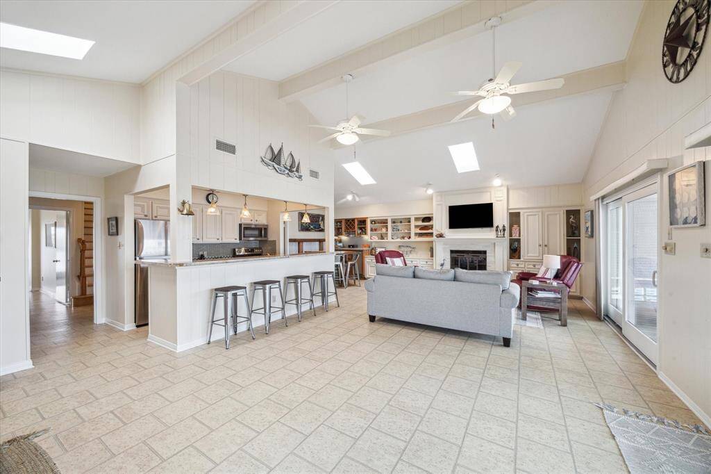 Step inside into the spacious open living area.  With multiple gathering areas, it's the ideal space for indoor family fun. The lofted ceiling with skylights keep it airy and bright.