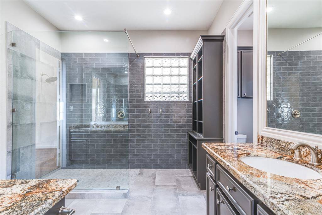 Another view of the spectacular shower plus built in storage cabinetry and dual vanities.