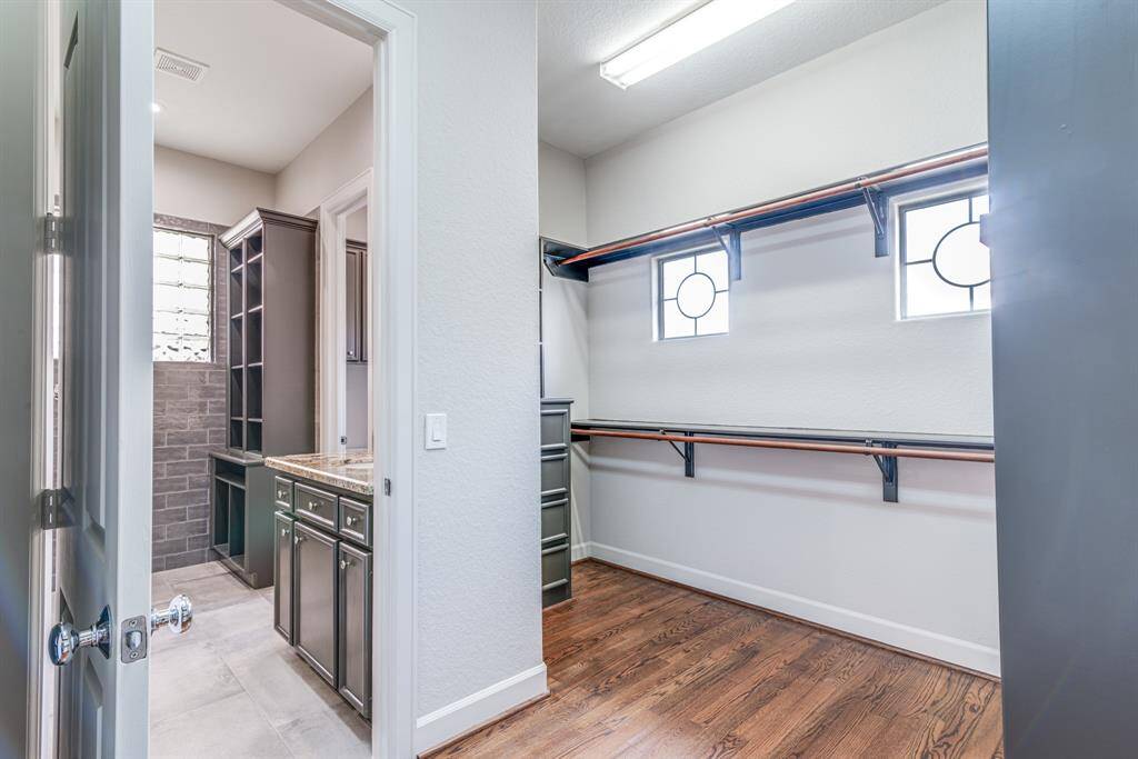 View from your dream walk in closet into the primary bathroom. Great storage and built in organization. Enjoy the added natural light.
