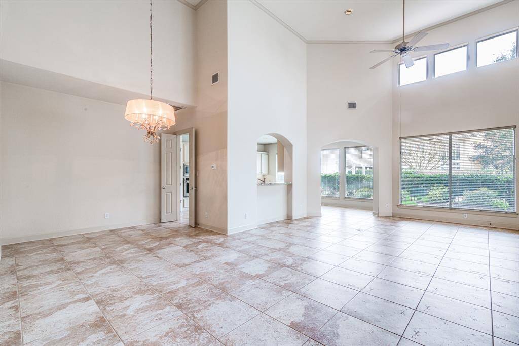 Dining and living space with 18' ceiling gorgeous tile flooring and views of rear yard.