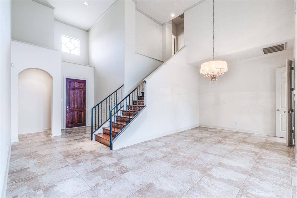 Dining space has kitchen connection and beautiful chandelier. Notice the updated iron railings on staircase.