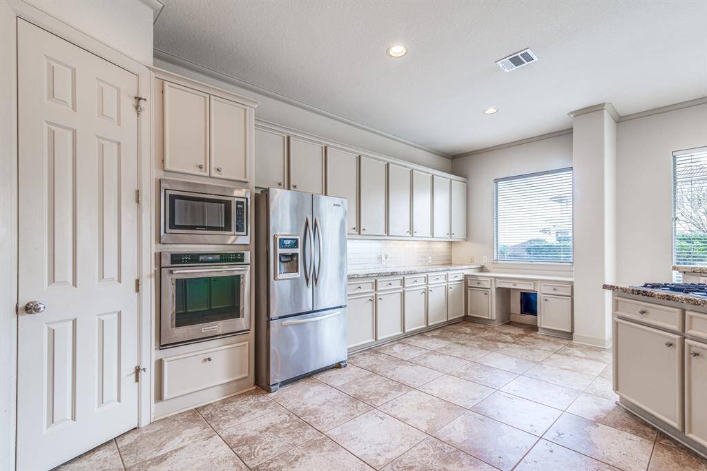 The kitchen stuns With so much space. 42" cabinets for abundance of storage. Lots of counter top area with updated gorgeous granite. Convenient desk area complete with doggy door!