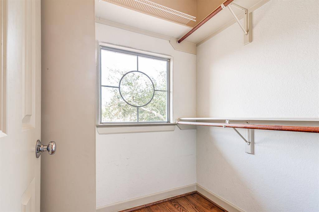 Walk in closet for second bedroom. Sturdy shelving and additional natural light from this nautical looking window.