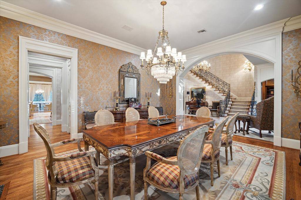 Butler’s pantry with oak hardwood floors, recessed lighting, custom millwork, built-in glass front cabinetry, brass hardware, marble countertop, KitchenAid ice maker, and storage closet for silver and fine china.