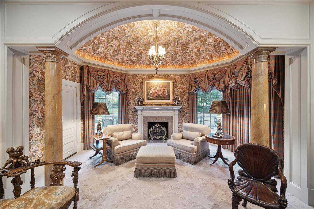 First primary bathroom with carpeted flooring, recessed lighting, brass chandelier, custom millwork, marble countertops, brass and porcelain plumbing fixtures, brass hardware, Palladian windows, and plantation shutters