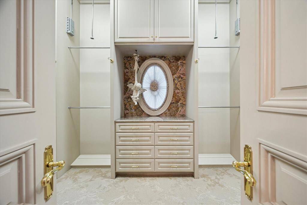 Second primary bathroom with carpeted flooring, recessed lighting, brass light fixture, custom millwork, marble countertop, brass and porcelain plumbing fixtures, brass hardware, Palladian windows, linen closet, and plantation shutters.