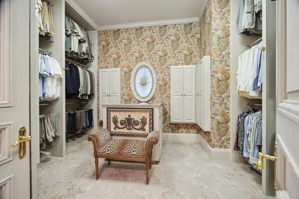 Powder bath with Limestone and Lueders tile flooring, brass and crystal chandelier, dual brass sconces, custom millwork, furniture style console, marble countertop, Sherle Wagner sink, brass cherub plumbing fixtures, and brass hardware.