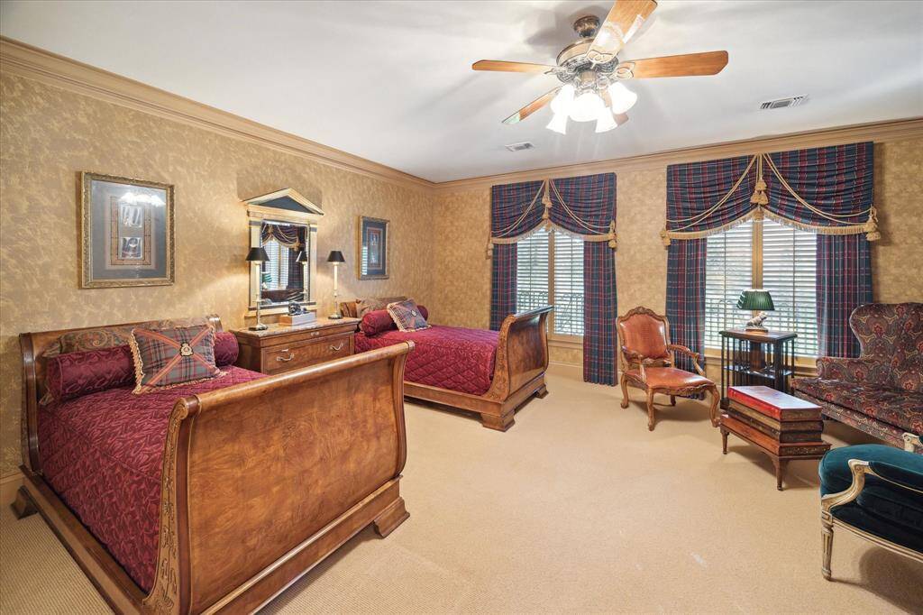 Secondary bathroom with carpeted and tile flooring, Hollywood lighting, recessed lighting, custom millwork, single sinks, brass and porcelain hardware, built-in cabinetry and drawers for linens, and tub/shower combo.