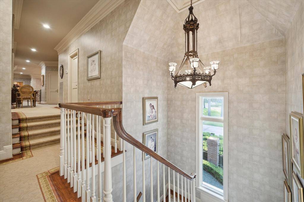 Guest suite living room with carpeted flooring, recessed lighting, ceiling fan with light, custom millwork, Palladian windows, plantation shutters and 3 storage closets.
