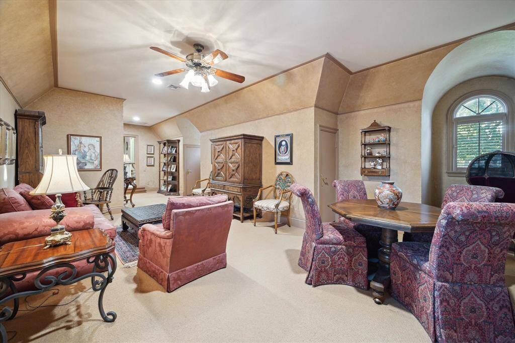 Guest bedroom with carpeted flooring, track lighting, ceiling fan with light, custom millwork, Palladian windows, plantation shutters, and dual closets.