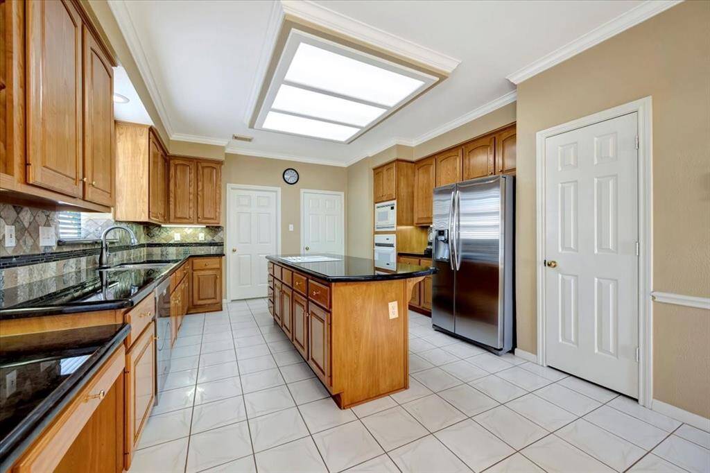 This kitchen has a wonderful pantry that wraps under the stairs. The door on the right leads to the dining room and the door on the left is the utility room.