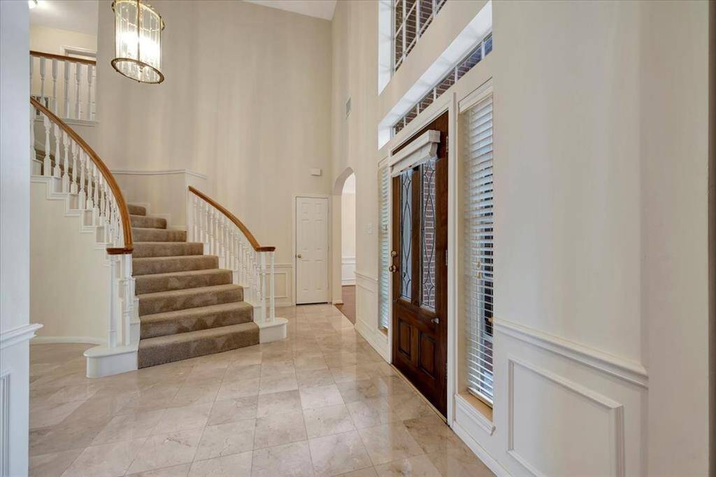 Beautiful sweeping staircase looking toward the dining room.