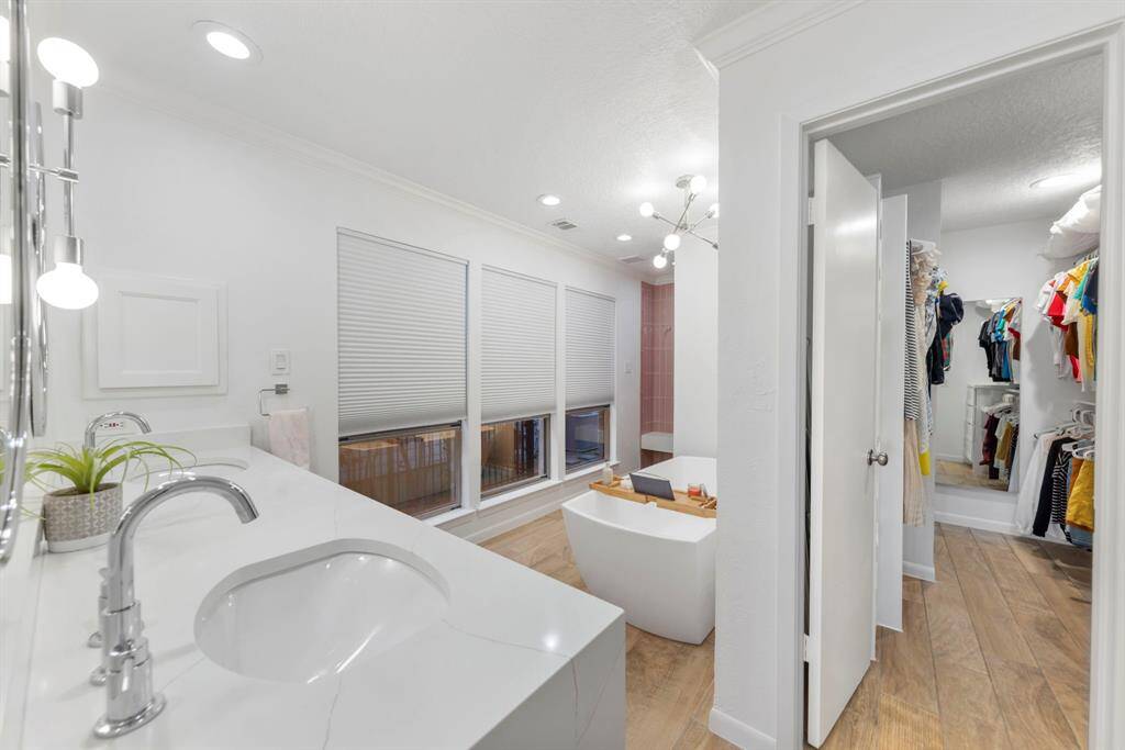 The renovated primary bathroom features a spacious walk-in closet with custom built-ins, offering ample storage and organization.