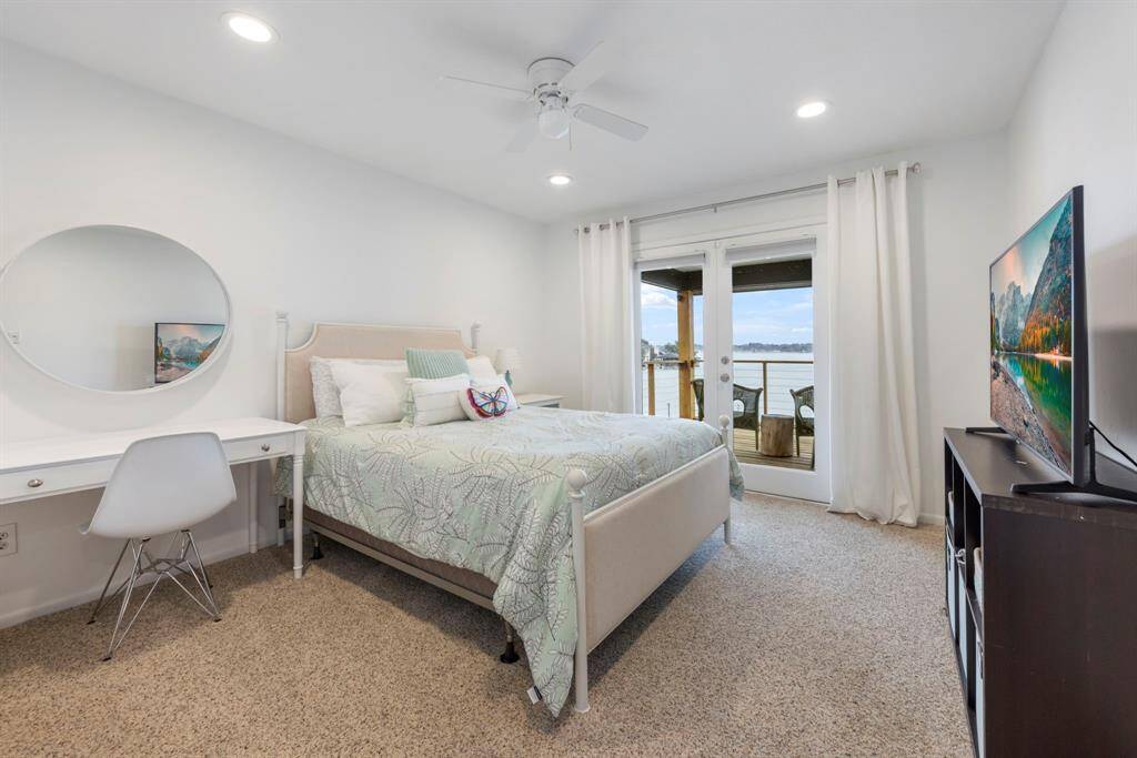 The final upstairs secondary bedroom features plush carpet and private access to the expansive second-floor wrap-around deck.