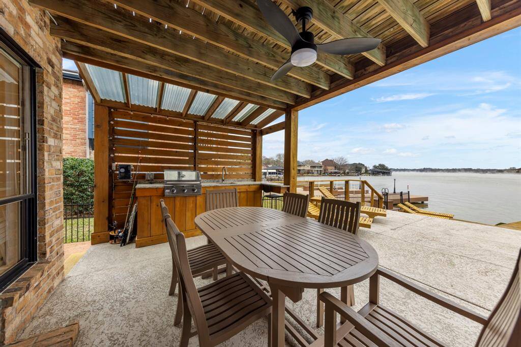 Back downstairs, step outside to the covered patio—perfect for dining al fresco. The outdoor kitchen features bar-top seating, ideal for entertaining with unbeatable lake views!