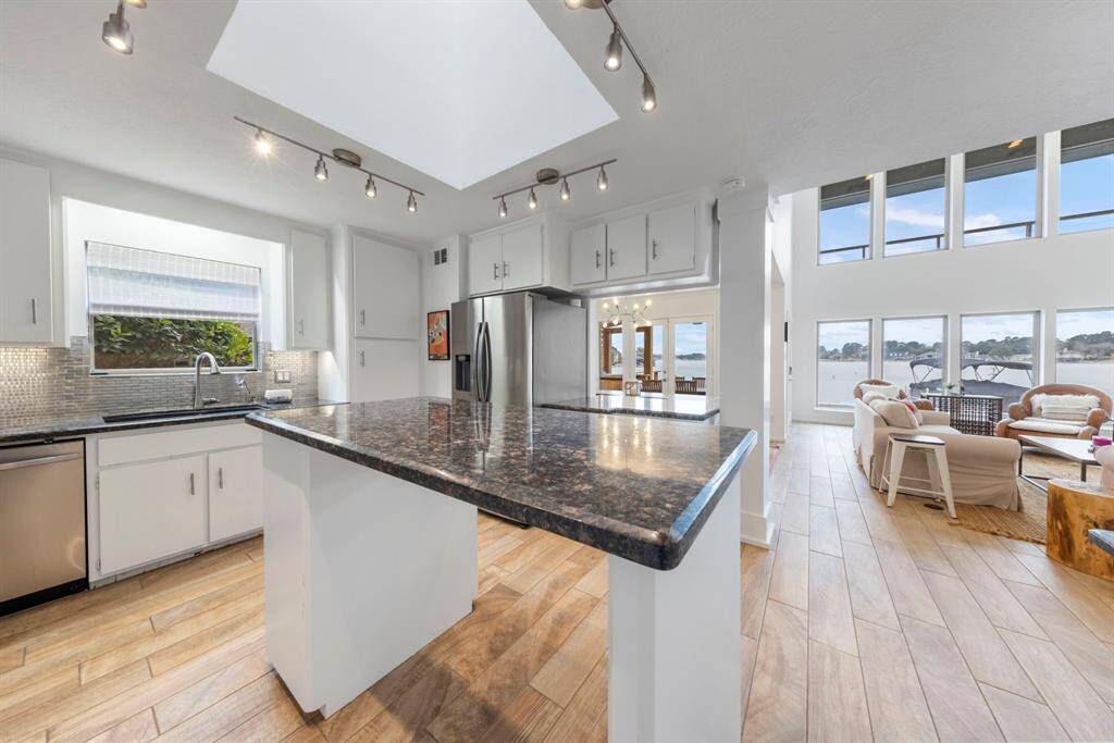 An island provides ample room for meal prep, while the breakfast bar offers additional seating, making it perfect for casual dining and entertaining.