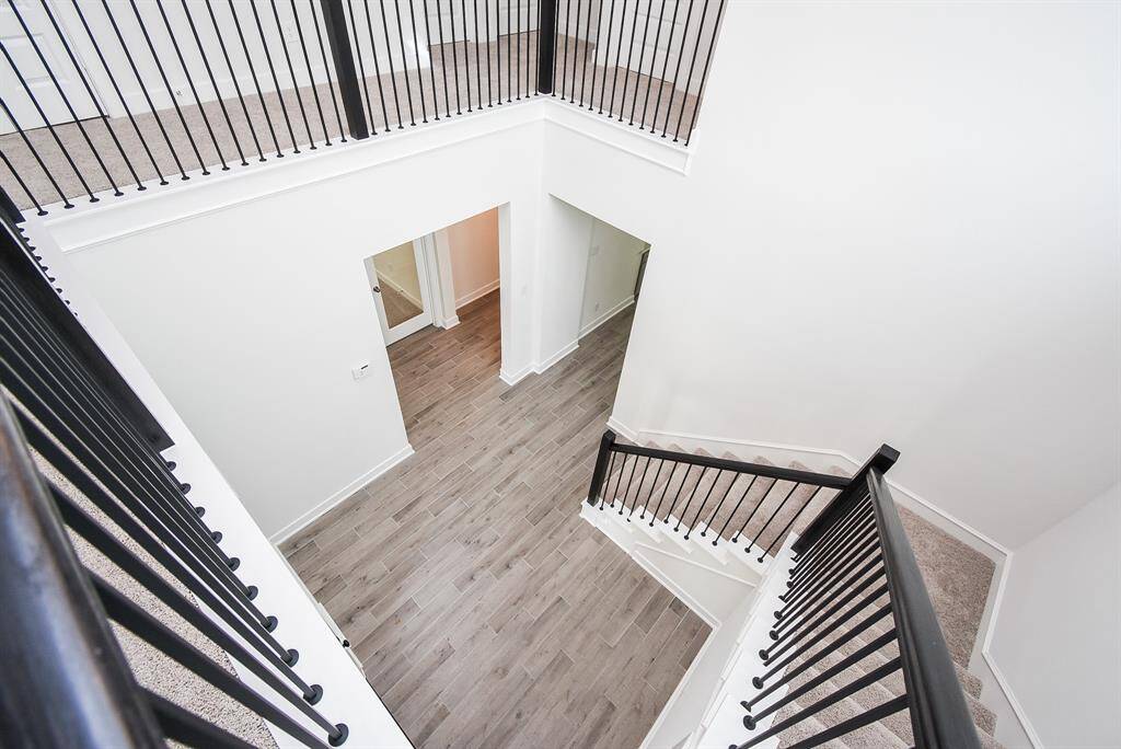 Open upstairs landing with a view of the modern staircase below.
