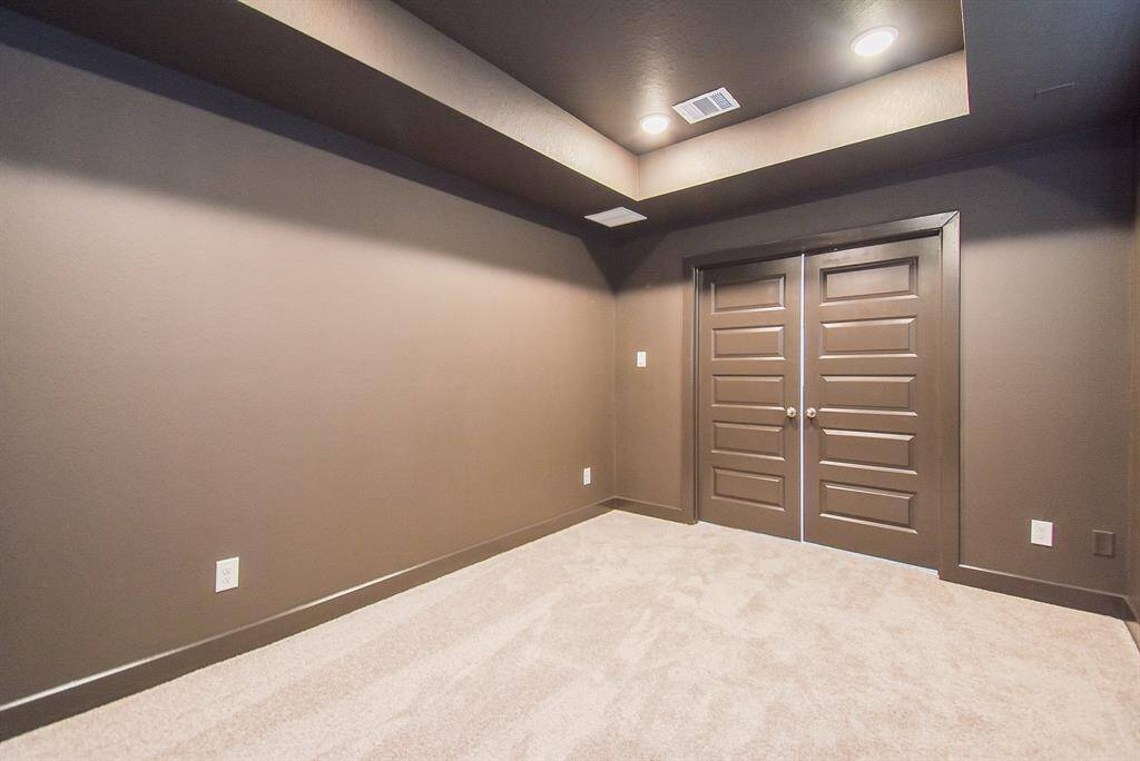 Modern home theater room with recessed lighting and soundproof walls.
