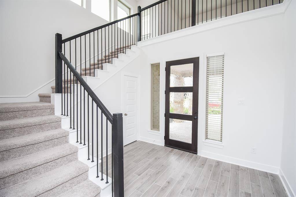 Open-concept entryway featuring a chic modern staircase.
