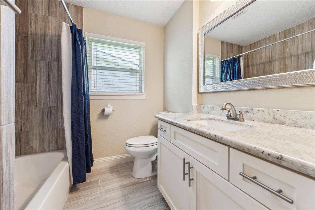 The stylish secondary bath, features a convenient shower-tub combo. Recently updated with modern shaker cabinets, stylish tile and granite countertops.