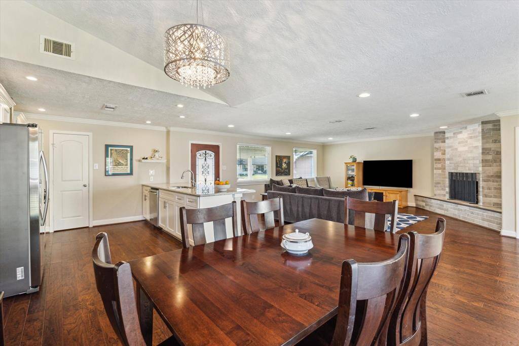Step back into the heart of the home, where a vaulted ceiling adds a dramatic and airy feel to the entire space. The dining area is elegantly accented by a sparkling chandelier as a stunning focal point.