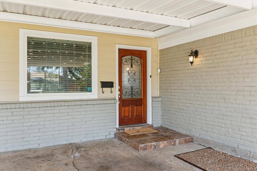 A covered carport and a stylish slatted entry welcome you to the home.