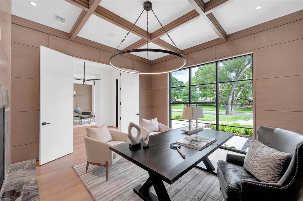 Adjacent and adjoining the kitchen is the living room. It is a huge space with surround sound, dual sided fireplace, quarter sawn white oak floors, fully open sliding doors and remarkable views of the pool, patio and yard.