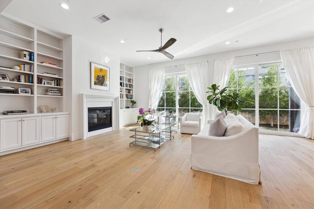 The family room features built-ins to the ceiling for displaying decorative elements. The stunning and oversized Lanai-style doors slide open wide for those glorious days.