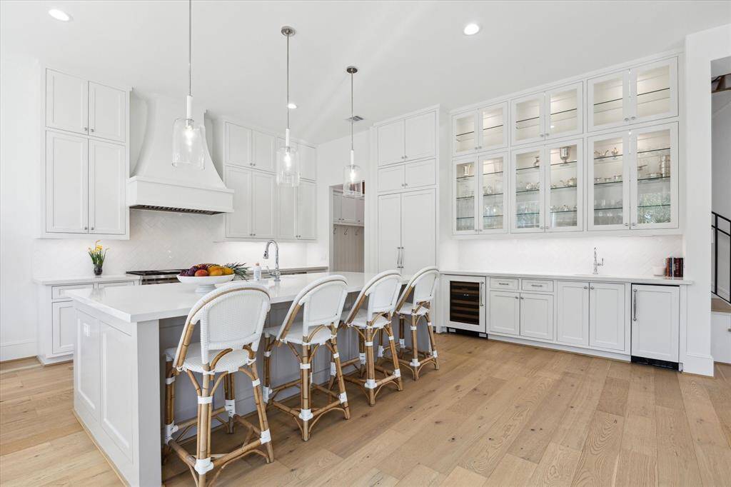 Notice the  glass front and lit cabinets that go to the ceiling. With extensive counter space, a second sink, beverage refrigerator and ice maker, this area functions as the perfect butlers pantry, food service area, as well as wet bar.