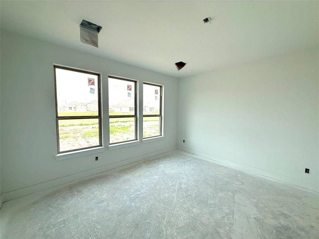 As you enter the primary bedroom, you’re greeted by an abundance of natural light pouring